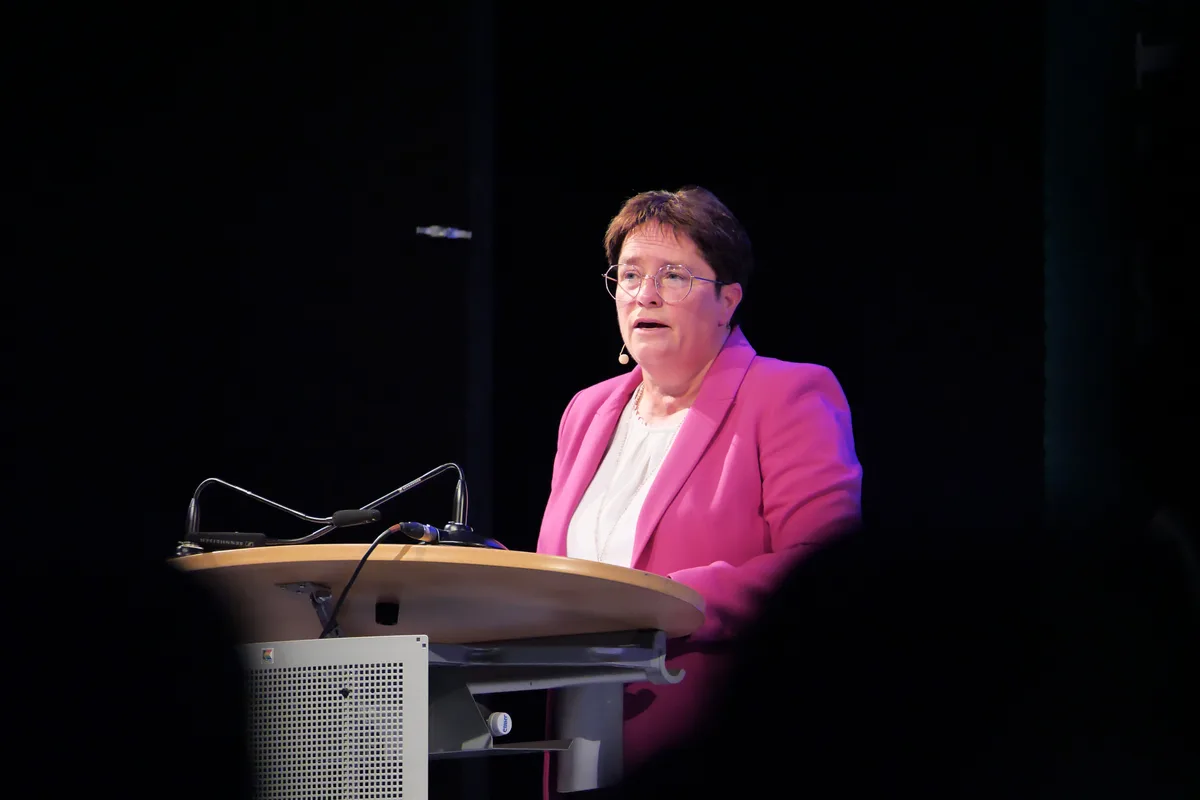 Magdalena Martullo-Blocher steht hinter einem Rednerpult und spricht zum Publikum. Sie trägt einen pinkfarbenen Sakko.